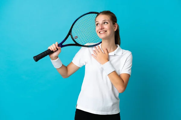 若いです女性テニス選手孤立しました上の青の背景を見ます上の笑顔 — ストック写真