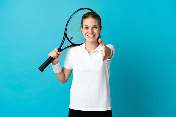 若いです女性テニスプレーヤー分離上の青背景揺れ手のために閉じますA良い取引 — ストック写真