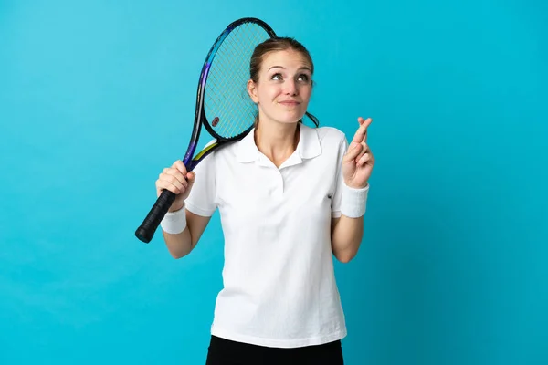 若いです女性テニス選手隔離されました青の背景に指が交差し ベストを願っています — ストック写真