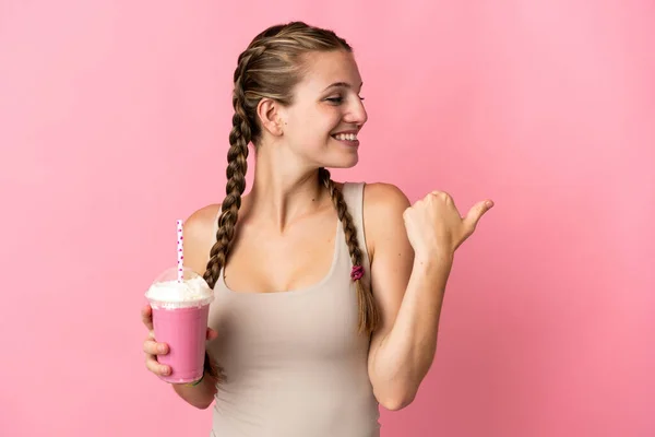 Jeune Femme Avec Milkshake Fraise Isolé Sur Fond Rose Pointant — Photo