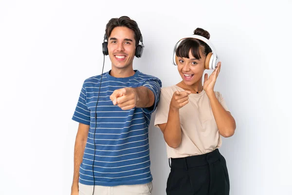 Jovens Amigos Mestiços Isolados Fundo Branco Ouvindo Música Apontando Para — Fotografia de Stock