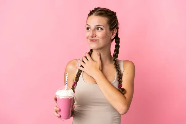 Mujer Joven Con Batido Fresa Aislado Sobre Fondo Rosa Mirando —  Fotos de Stock