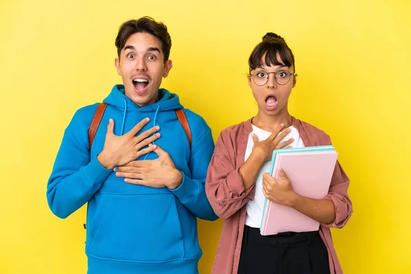 Junges Studentenpaar Auf Gelbem Hintergrund Überrascht Und Schockiert Während Nach — Stockfoto