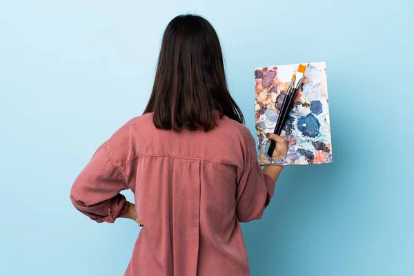 Joven Artista Mujer Sosteniendo Una Paleta Sobre Fondo Azul Aislado —  Fotos de Stock