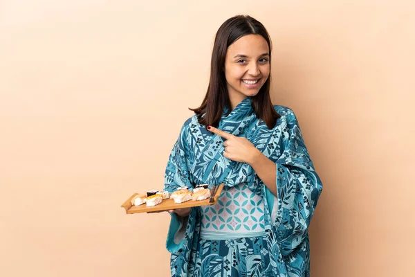 Frau Trägt Kimono Und Hält Sushi Über Einen Isolierten Hintergrund — Stockfoto