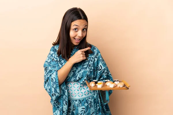 Frau Trägt Kimono Und Hält Sushi Über Einen Isolierten Hintergrund — Stockfoto