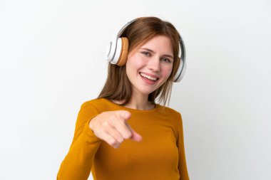 Genç İngiliz kadın beyaz arka planda izole edilmiş müzik dinliyor.