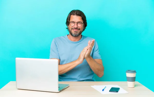 Homem Holandês Sênior Uma Mesa Com Laptop Isolado Fundo Azul — Fotografia de Stock