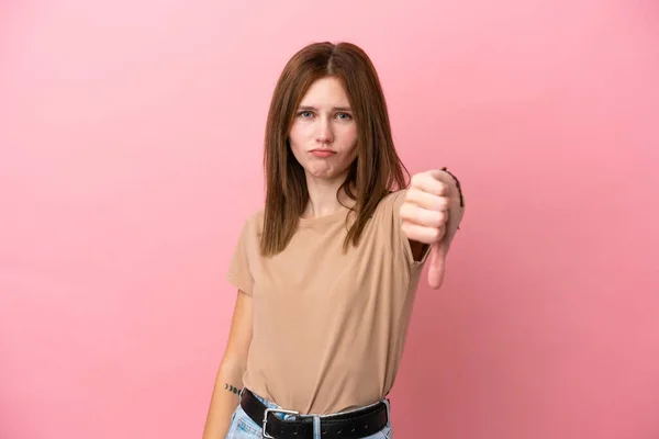 若い英語の女性は 負の式で親指を示すピンクの背景に隔離されました — ストック写真