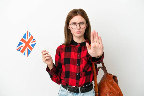 举着英国国旗的年轻女子因蓝色背景而被隔离 做了停止姿势 — 图库照片