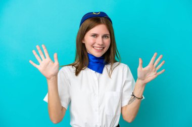 Uçak hostesi İngiliz kadın mavi arka planda izole edilmiş parmaklarıyla ona kadar sayıyor.