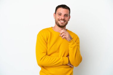 Genç Brezilyalı adam beyaz arka planda izole edilmiş gülüyor.