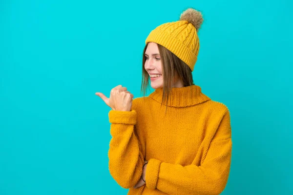 Ung Engelsk Kvinna Bär Vinter Jacka Isolerad Blå Bakgrund Pekar — Stockfoto