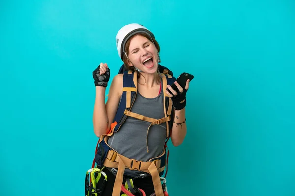Jovem Inglesa Alpinista Mulher Isolada Fundo Azul Com Telefone Posição — Fotografia de Stock