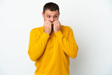 Beyaz arka planda izole edilmiş genç Brezilyalı gergin ve korkmuş bir adam elleriyle suni teneffüs yapıyor.