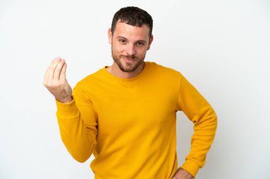 Beyaz arka planda izole edilmiş genç Brezilyalı adam İtalyan jestleri yapıyor.