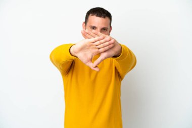 Genç Brezilyalı bir adam beyaz arka planda izole edilmiş bir şekilde bir eylemi durdurmak için el hareketi yapıyor.