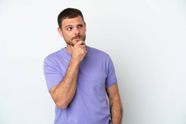 Genç Brezilyalı adam beyaz arka planda izole edilmiş ve yukarı bakıyor.