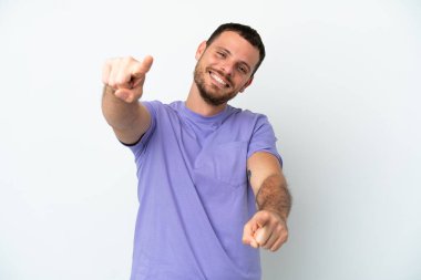 Beyaz arka planda izole edilmiş genç Brezilyalı adam mutlu bir ifadeyle öne bakıyor.