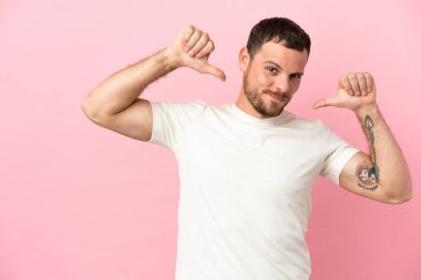 Genç Brezilyalı bir adam pembe arka planda soyutlanmış gururlu ve kendinden memnun