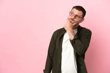 Pembe arka planda izole edilmiş genç Brezilyalı adamın şüpheleri var.