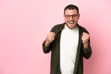 Pembe arka planda kalan Brezilyalı genç adam galibiyeti kutluyor.