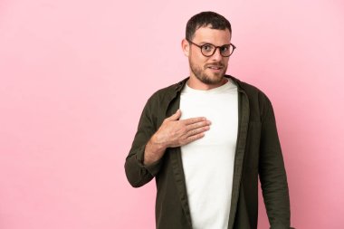Pembe arka planda izole edilmiş genç Brezilyalı adam kendini işaret ediyor.
