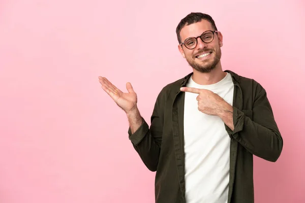 Jovem Brasileiro Isolado Fundo Rosa Segurando Copyspace Imaginário Palma Mão — Fotografia de Stock