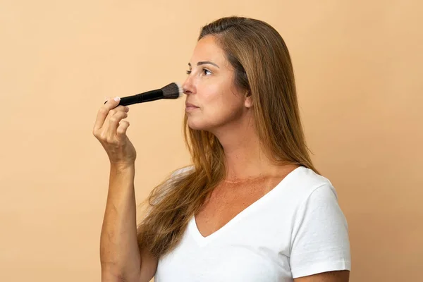 Medelålders Brasilianska Kvinna Isolerad Beige Bakgrund Hålla Makeup Borste — Stockfoto