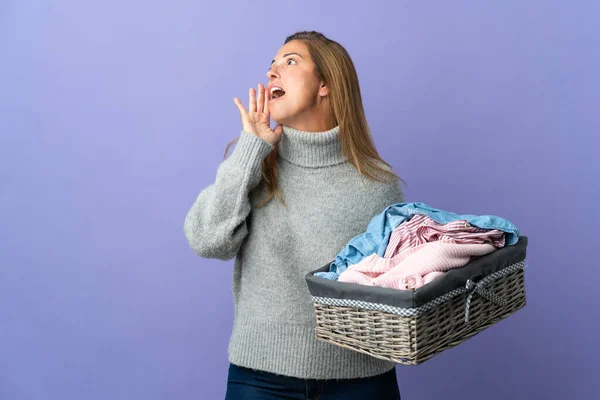 Középkorú Kezében Egy Ruha Kosár Elszigetelt Lila Háttér Kiabálás Száj — Stock Fotó