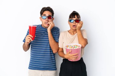 Beyaz arka planda 3 boyutlu gözlüklü ve elinde patlamış mısırla genç melez arkadaşlar.