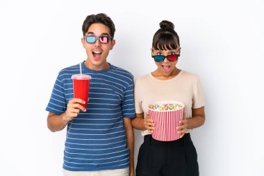 Beyaz arka planda 3 boyutlu gözlüklü ve elinde patlamış mısırla genç melez arkadaşlar.