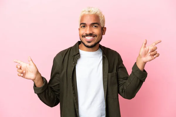 Young Colombian Handsome Man Isolated Pink Background Pointing Finger Laterals — Stock Photo, Image