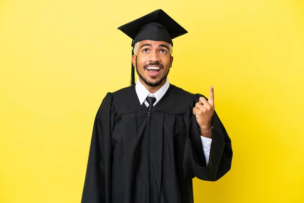 Junger Universitätsabsolvent Kolumbianischer Mann Isoliert Auf Gelbem Hintergrund Zeigt Nach — Stockfoto