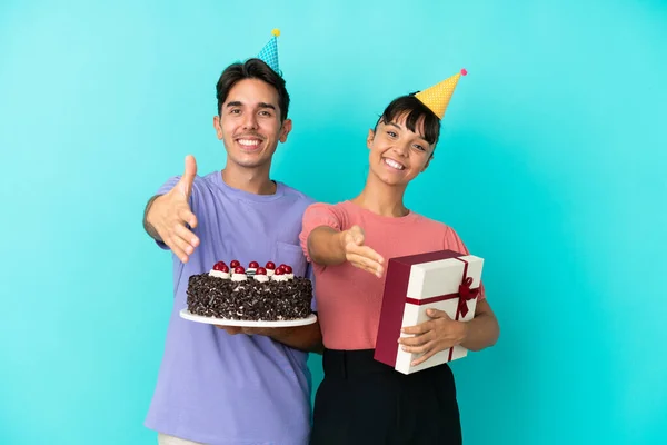 若いです混合レースカップル保持誕生日ケーキとプレゼント絶縁上の青の背景揺れ手のために閉鎖良い取引 — ストック写真