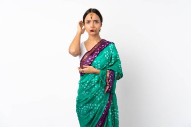 Beyaz arka planda izole edilmiş genç Hintli kadının şüpheleri var.