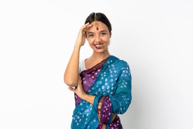 Genç Hintli kadın beyaz arka planda izole edilmiş, mutlu bir ifadeyle selamlıyor.