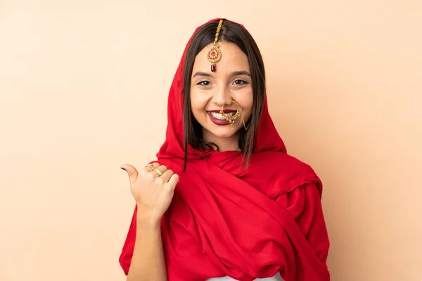 Mladá Indická Žena Izolované Béžové Pozadí Ukazuje Stranu Prezentovat Produkt — Stock fotografie