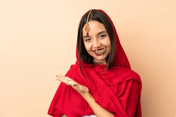 Jovem Indiana Mulher Isolado Bege Fundo Apresentando Uma Ideia Enquanto — Fotografia de Stock