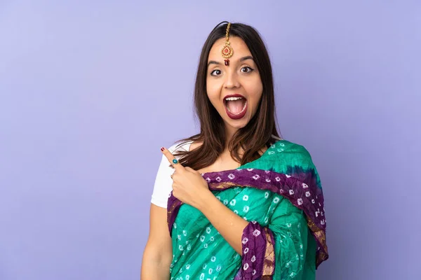 Mujer India Joven Aislada Sobre Fondo Púrpura Sorprendida Señalando Lado —  Fotos de Stock