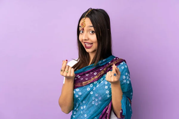 紫の背景に孤立した若いインド人女性はお金のジェスチャーを作る — ストック写真