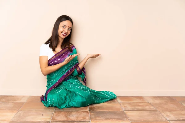 Young Indian Woman Sitting Floor Extending Hands Side Inviting Come — Stock Photo, Image
