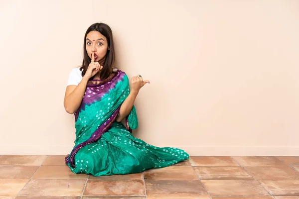 Mujer India Joven Sentada Suelo Señalando Hacia Lado Haciendo Gesto —  Fotos de Stock