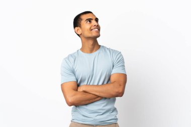 Afrika kökenli beyaz bir adam gülümserken yukarı bakıyor.