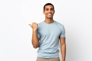 İzole edilmiş beyaz arka planı olan Afrikalı Amerikalı bir adam bir ürün sunmak için kenarı işaret ediyor.