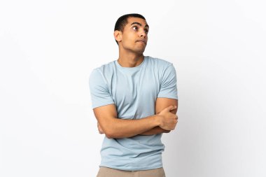 Omuzlarını kaldırırken şüpheyle hareket eden izole beyaz arka plan üzerinde Afrikalı Amerikalı bir adam