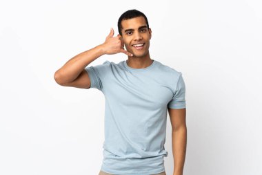 İzole edilmiş beyaz arka planı olan Afro-Amerikalı bir adam telefon hareketi yapıyor. Bana geri dönüş işareti ver.