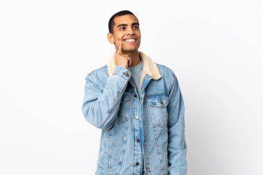 İzole edilmiş beyaz arka planı olan Afrikalı Amerikalı bir adam yukarı bakarken bir fikir düşünüyor.