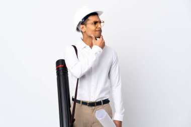 Miğferi olan ve izole edilmiş beyaz arka plan üzerinde planları olan Afrikalı Amerikalı mimar şüpheleri var.