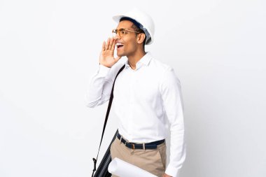 Miğferli Afrikalı Amerikalı mimar izole edilmiş beyaz arka plan üzerinde planlar tutuyor ve ağzı açık bağırıyor.